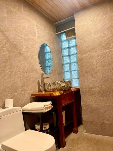 a bathroom with a sink and a toilet and a mirror at Homestay Ocbien in Hoi An