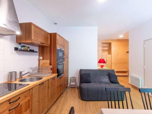 - une cuisine avec un évier et un canapé dans l'établissement Appartement cosy à Cauterets avec balcon, centre-ville, 2 chambres, pour 4 à 6 personnes - FR-1-401-296, à Cauterets
