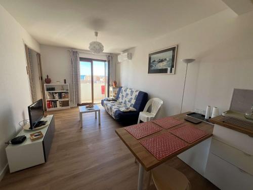 un salon avec un canapé et une table dans l'établissement T2 avec climatisation, balcon vue mer, 250m de la plage - FR-1-701-83, à Valras-Plage