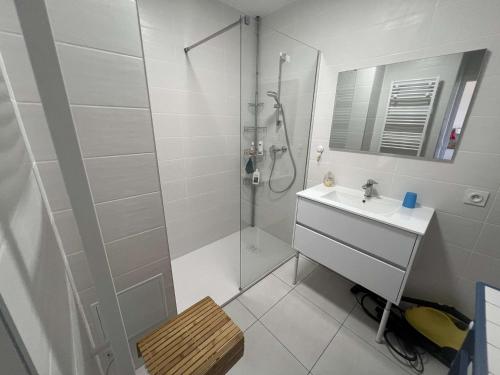 une salle de bain blanche avec une douche et un lavabo dans l'établissement T2 avec climatisation, balcon vue mer, 250m de la plage - FR-1-701-83, à Valras-Plage