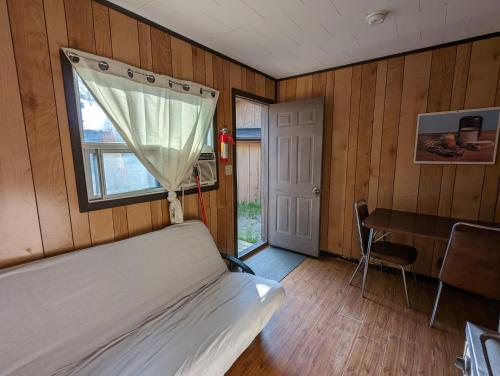 una camera da letto con un letto, una scrivania e una finestra di Tiny Wood Cottage 16 a Wasaga Beach