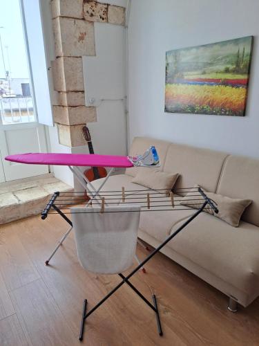 a pink table in a living room with a couch at A Levante in Putignano