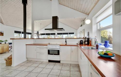 a kitchen with white cabinets and a counter top at Holiday Home Pengeurtvej Vordingborg V in Vordingborg