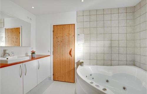 a white bathroom with a tub and a sink at Holiday Home Pengeurtvej Vordingborg V in Vordingborg