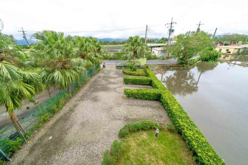 an aerial view of a river with palm trees and a person at Fish Nest Villa 宜蘭親子包棟民宿 戲水池 歡唱 代訂晚餐 in Dongshan