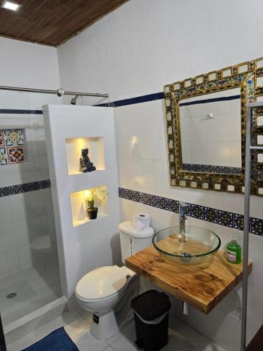 a bathroom with a sink and a toilet and a mirror at Casa Hotel Victoria Real in Mariquita