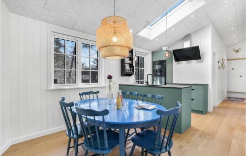 a dining room with a blue table and chairs at Amazing Home In Nexø With Kitchen in Neksø
