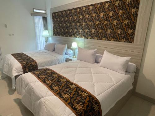 a hotel room with two beds and a painting on the wall at Rent Studio2 full furnished in Jakarta