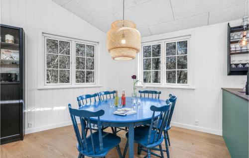 a dining room with a blue table and chairs at Amazing Home In Nexø With Kitchen in Neksø