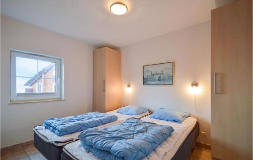 two beds in a room with blue pillows on them at Holiday Home Romo With Sea View 154 in Bolilmark