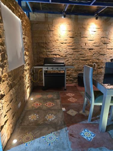 a kitchen with a stove in a stone wall at Casa Hotel Victoria Real in Mariquita
