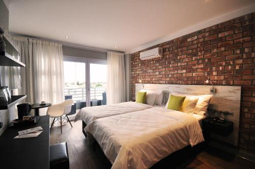 スワコプムントにあるSwakopmund Plaza Hotelのレンガの壁と大型ベッドが備わるベッドルーム1室が備わります。