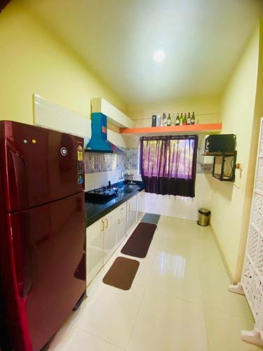 モージムにある2bhk by the beachのキッチン(黒い冷蔵庫、白いキャビネット付)