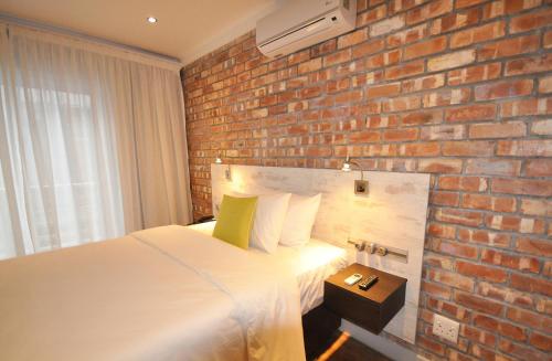 a bedroom with a brick wall and a bed at Swakopmund Plaza Hotel in Swakopmund
