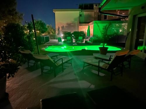 a patio with chairs and a pool at night at Apartments Bego Spa & Wellness in Crikvenica
