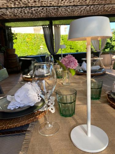 a table with a white lamp and glasses on it at Apartments Bego Spa & Wellness in Crikvenica