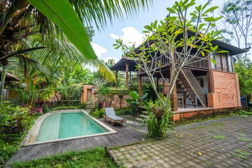 a villa with a swimming pool in front of a house at Ubud Sawah Scenery Villa and Homestay in Tegalalang