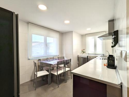 eine Küche mit einem Tisch und Stühlen in einer Küche in der Unterkunft Casa moderno en Renedo de Pielagos in Renedo de Piélagos