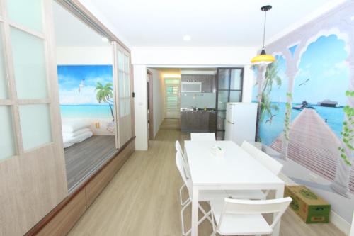 a dining room with a white table and a bedroom at Sea Keelung in Keelung