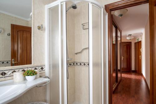 een badkamer met een douche met wastafel en spiegel bij Apartamento en el centro in Santander