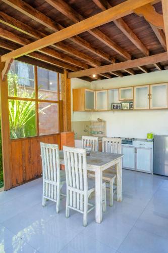 a kitchen with a table and chairs in a kitchen at Ubud Sawah Scenery Villa and Homestay in Tegalalang