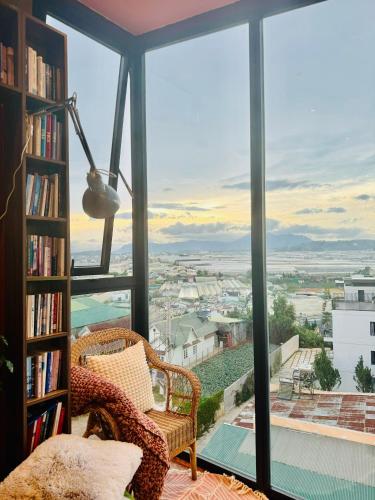 a room with a book shelf and a chair and a window at Âm Ấm Đà Lạt Boutique Hotel & Cozy Bistro in Khu Chi Lăng