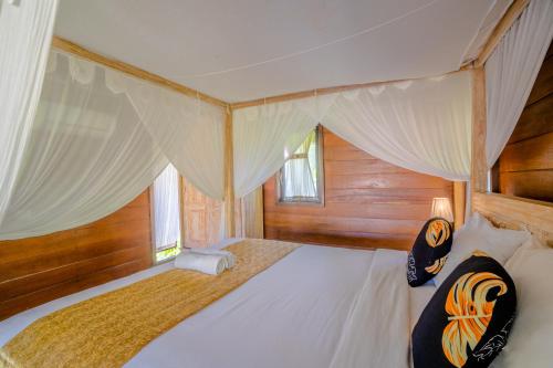 a bedroom with a bed with a canopy at Ubud Sawah Scenery Villa and Homestay in Tegalalang
