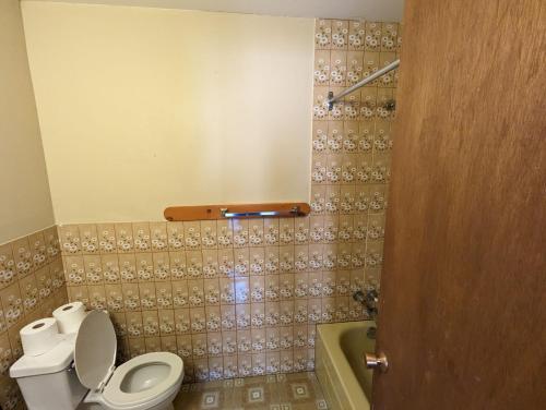 een badkamer met toilet en ligbad bij Tiny Wood Cottage 21 in Wasaga Beach