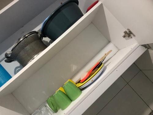 a drawer in a cabinet with a pot and chopsticks at Serene Ongata Rongai Studio Bnb in Nairobi