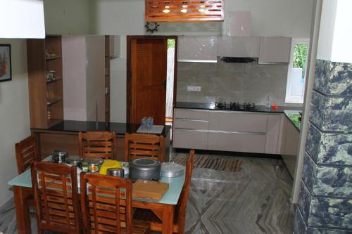 a kitchen with a table and chairs and a counter at Airy Homestay Ooty by Lexstays in Ooty