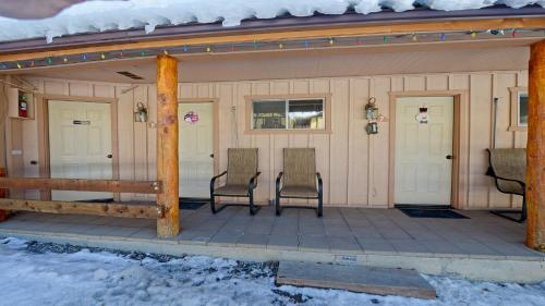 een overdekte veranda met twee stoelen erop in de sneeuw bij Arrowhead 06 in Red River