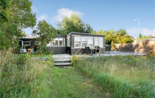 オーベンローにある2 Bedroom Nice Home In Aabenraaの野原に腰掛けた黒小屋