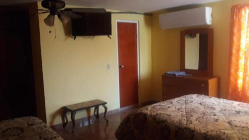 a bedroom with a bed and a tv on the wall at Apartamento División del Norte Planta Alta in Matamoros