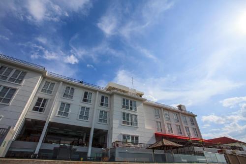 a white building with a blue sky in the background at Hotel on The Rock in Kupang