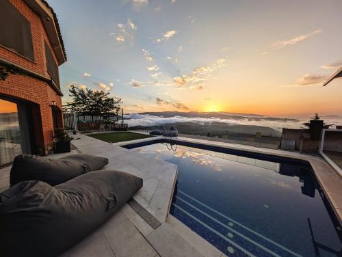 a swimming pool with pillows sitting next to a house at AranEtxea in Bigues i Riells