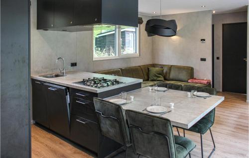 a kitchen with a stove and a table with chairs at 3 Bedroom Pet Friendly Home In Epe in Epe