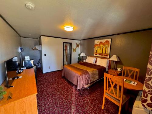 a hotel room with a bed and a desk at Cascade Lodge - Central Bend Retreat in Bend