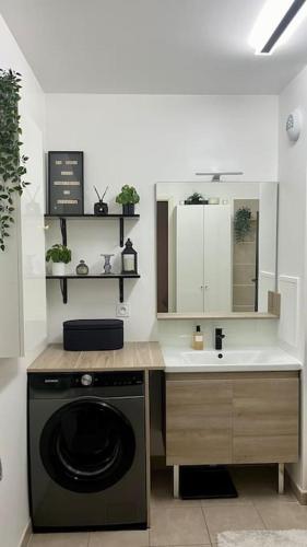 une cuisine avec une machine à laver et un évier dans l'établissement Moderne et bien situé La Défense JO Paris 2024, à Puteaux