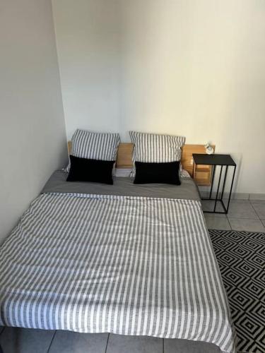 un lit avec deux oreillers dessus dans une chambre dans l'établissement Hébergement Studio, à Saint-Martin-des-Noyers