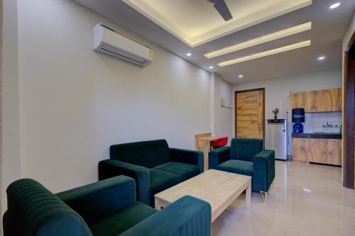 a waiting room with green chairs and a table at The Lodgers Luxury 1 BHK Serviced Apartment Near Golf Course Road Gurugram in Gurgaon