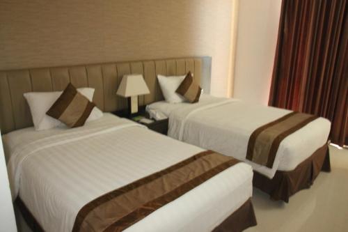a hotel room with two beds and a lamp at Hotel on The Rock in Kupang
