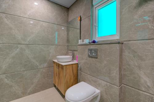 a bathroom with a toilet and a shower with a window at The Lodgers Luxury 1 BHK Serviced Apartment Near Golf Course Road Gurugram in Gurgaon