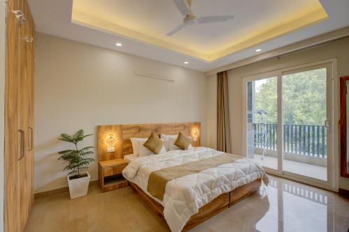 a bedroom with a large bed and a balcony at The Lodgers Luxury 1 BHK Serviced Apartment Near Golf Course Road Gurugram in Gurgaon