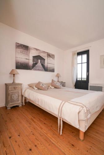 une chambre blanche avec un grand lit et une table dans l'établissement La charmante au bord du cher, à Saint-Avertin
