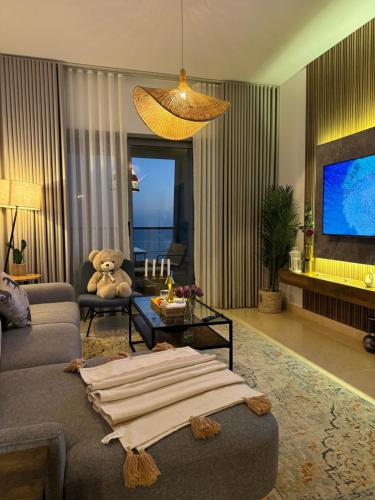 a living room with a teddy bear sitting on a couch at شقة فاخرة بإطلالة بحرية كاملة in Jeddah