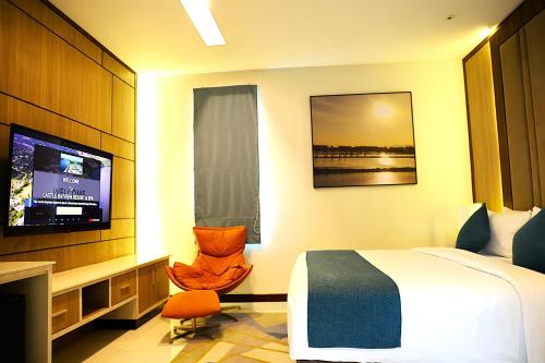 a hotel room with a bed and a flat screen tv at Castle Bayview Resort & Spa in Kampot