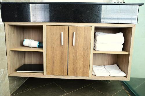 a wooden cabinet with towels in a bathroom at Castle Bayview Resort & Spa in Kampot