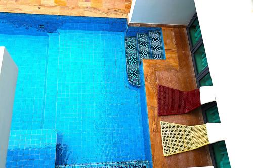 a swimming pool with blue tiles on the side of it at Castle Bayview Resort & Spa in Kampot
