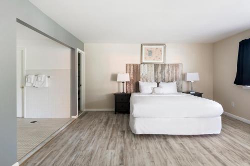 a bedroom with a large white bed and wooden floors at The Atlantic in Southampton