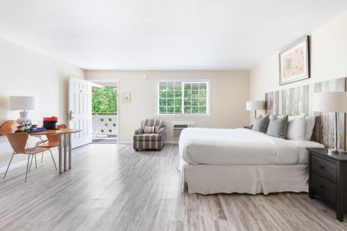 a white bedroom with a large bed and a desk at The Atlantic in Southampton
